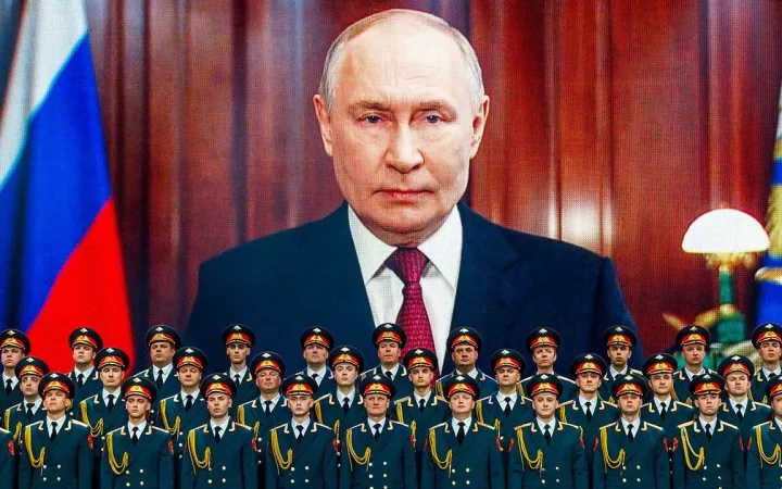 Vladimir Putin displayed on a giant screen above rows of Russian officers in uniform.