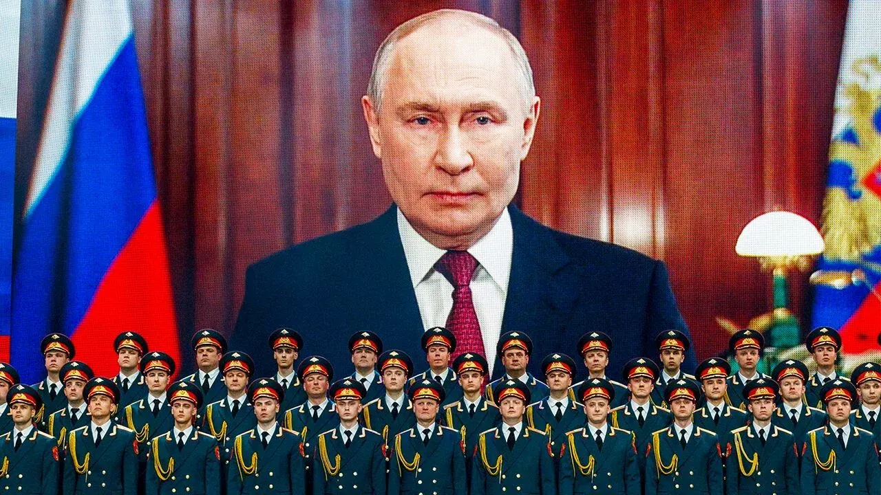 Vladimir Putin displayed on a giant screen above rows of Russian officers in uniform.