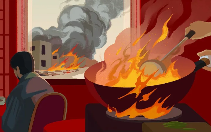 someone cooking with a flaming wok while a building is on fire outside the window