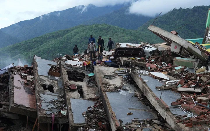 Residents search through the rubble of a building that collapsed in the earthquakes in La Guaira, Venezuela