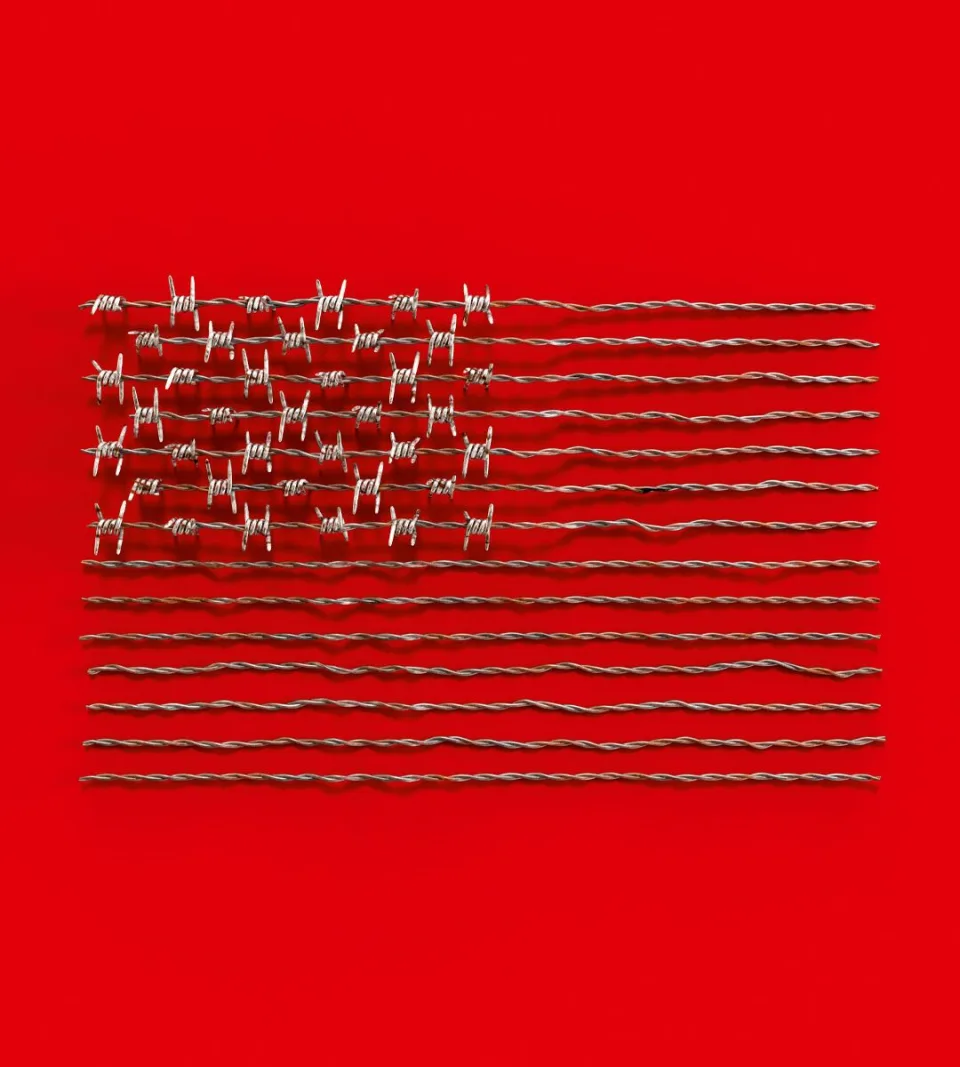 Barbed wire arranged in the shape of an American flag against a red background.