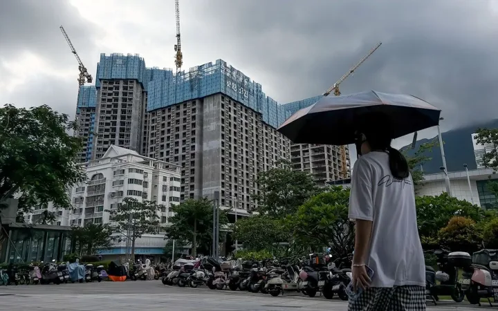 Pedestrian passing apartment towers being built in Shenzhen