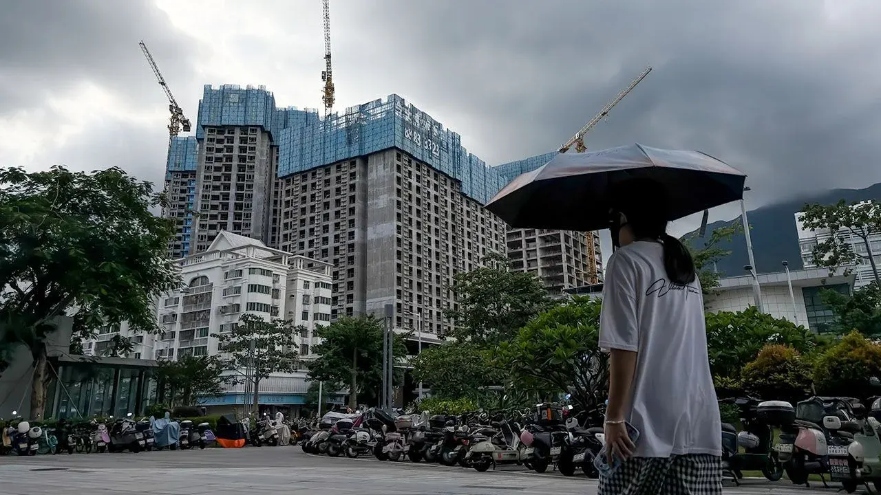 Pedestrian passing apartment towers being built in Shenzhen