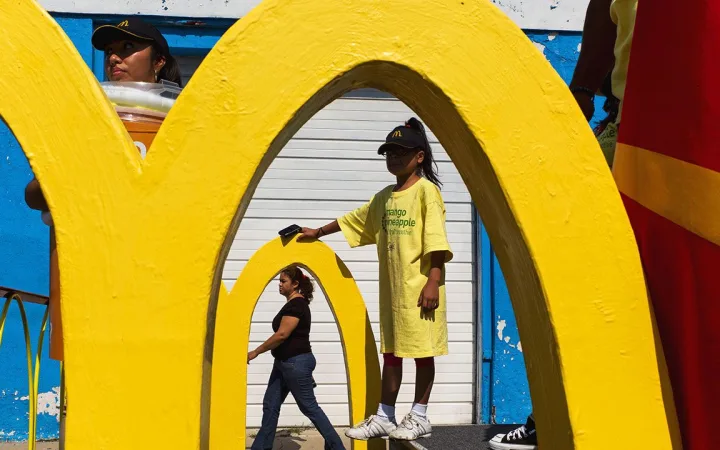 People walk past McDonald 'arches'.