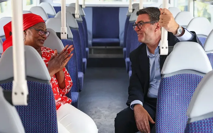 Prime Minister Andy Burnham chats with TikTok creator Bemi Orojuogun aboard a bus.