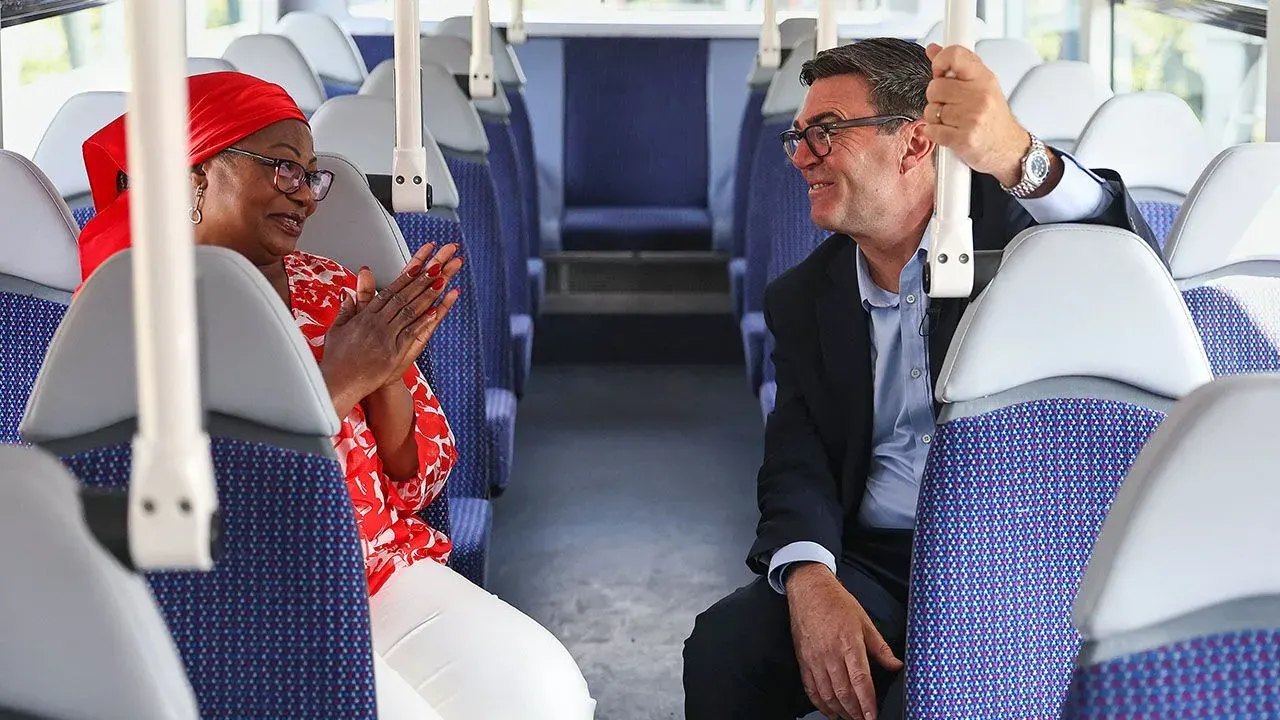 Prime Minister Andy Burnham chats with TikTok creator Bemi Orojuogun aboard a bus.