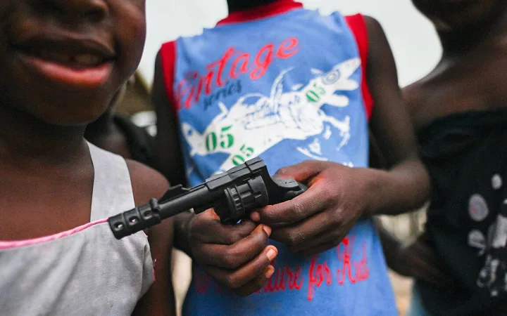 A boy holds a toy gun on a street of the Puente Nayero humanitarian area in Buenaventura, Valle del Cauca, Colombia