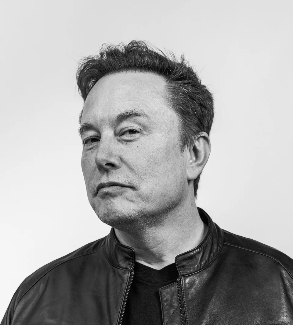 Black-and-white portrait of Elon Musk, wearing a leather jacket, looking to one side.