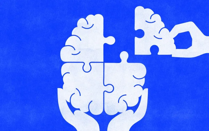 A hand places the final puzzle piece into a brain held in cupped hands, symbolizing restoring, completing, or improving mental health and cognitive wellbeing.