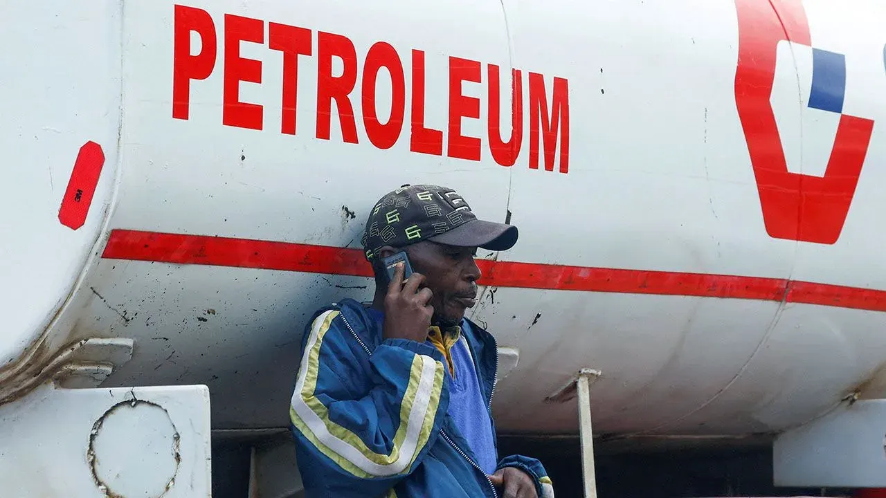 A man talks on his phone leaning against a fuel tanker in Nairobi, Kenya