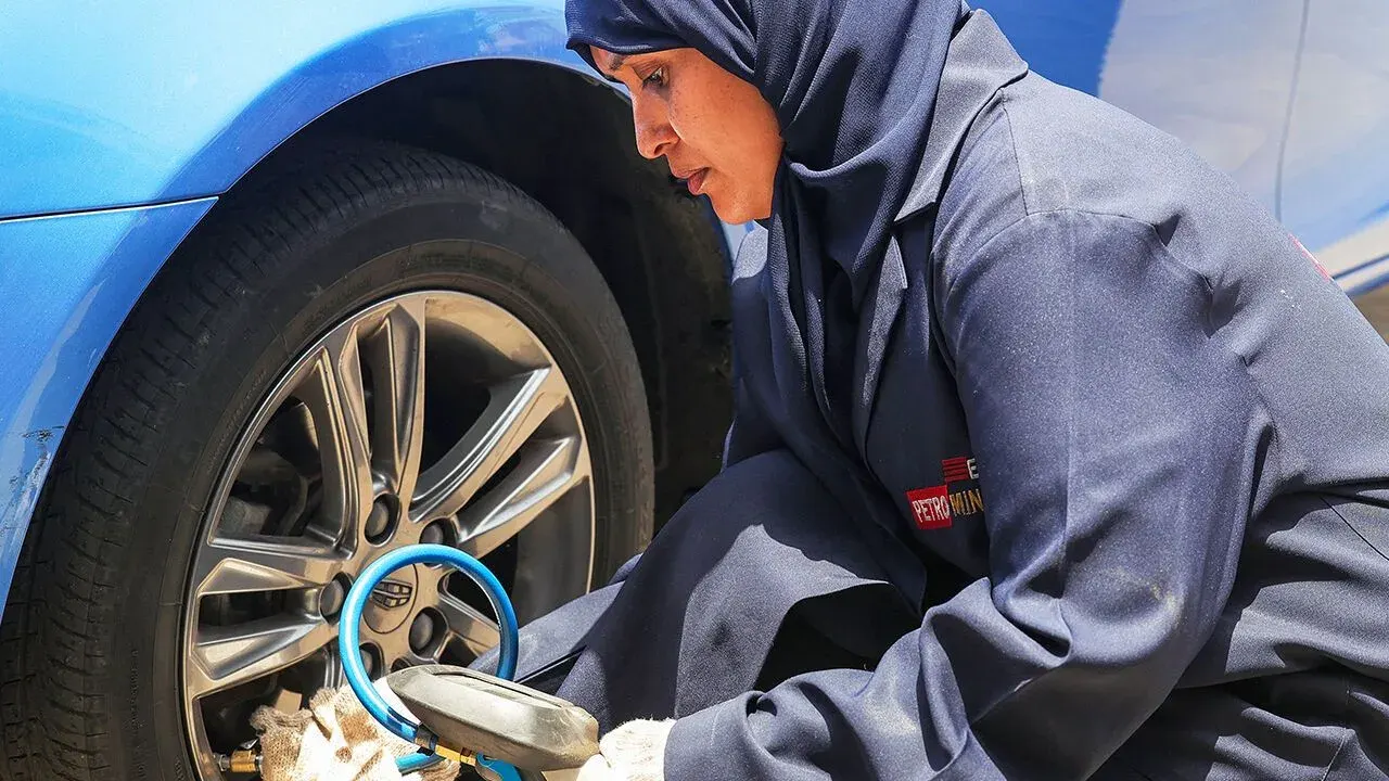 A Saudi woman working as a mechanic at an auto repair garage in Jedda