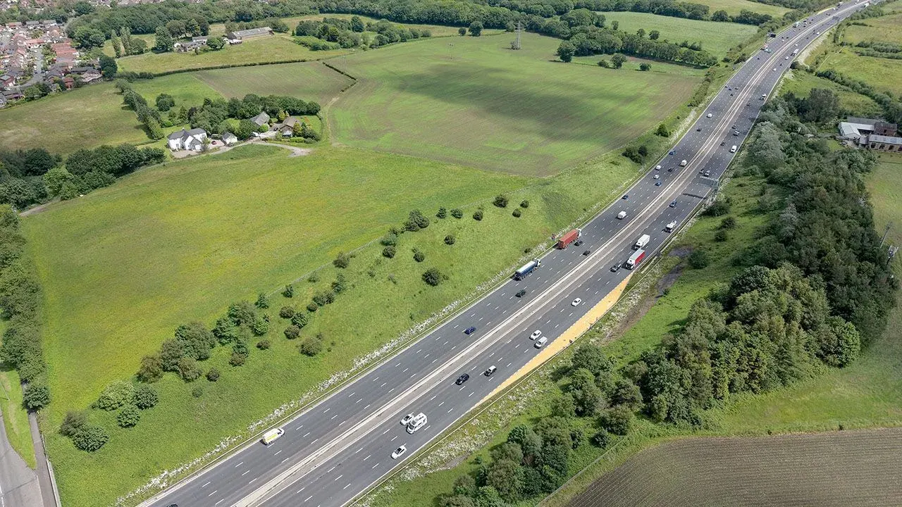 An aerial view of the M6 motorway cutting through a rural area of the Ashton-in-Makerfield parliamentary constituency