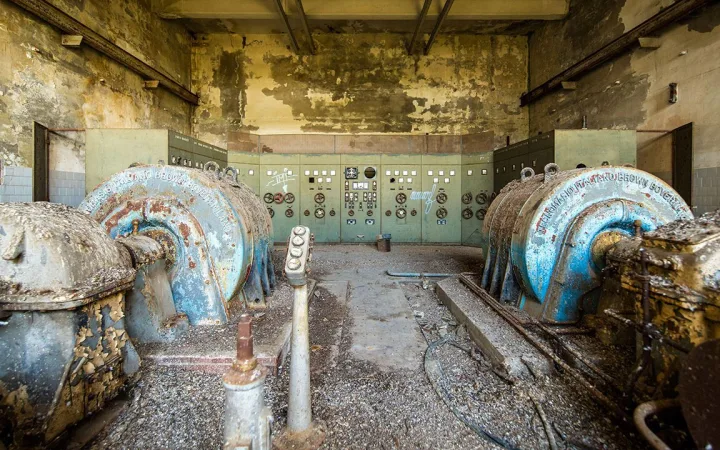 Control room for a derelict power station control room with rusty turbines, peeling paint and vintage industrial panels