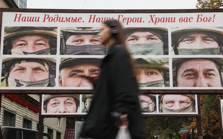 Pedestrian passing a display of portraits honouring Russian troops in the Ukraine campaign in Saint Petersburg