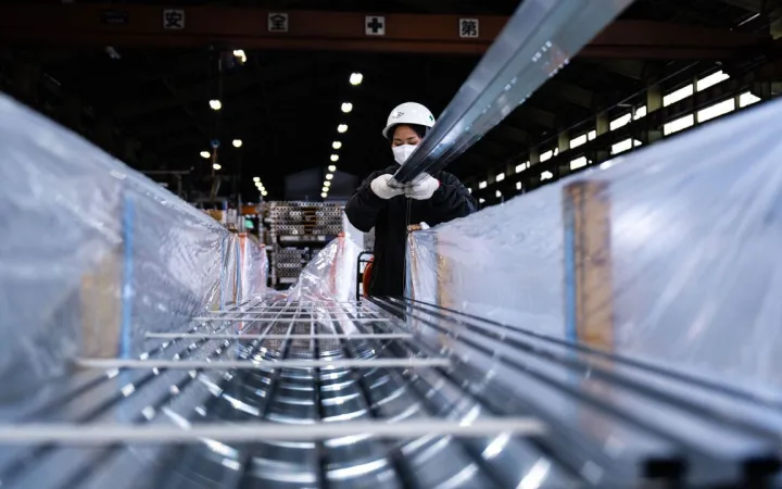 A worker packs aluminum extrusions for shipment at the Kato Light Metal Industry Co. factory in Kanie, Aichi prefecture, Japan.