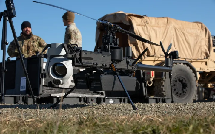 An Anduril Ghost-X drone on the ground with U.S. soldiers and a military vehicle behind it in Romania